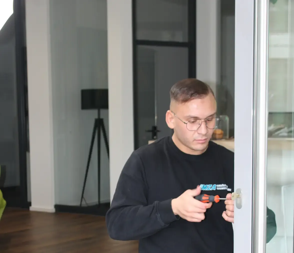 Anis Ziani arbeitet mit Schlüsseldienst-Werkzeug an einer Eingangstür